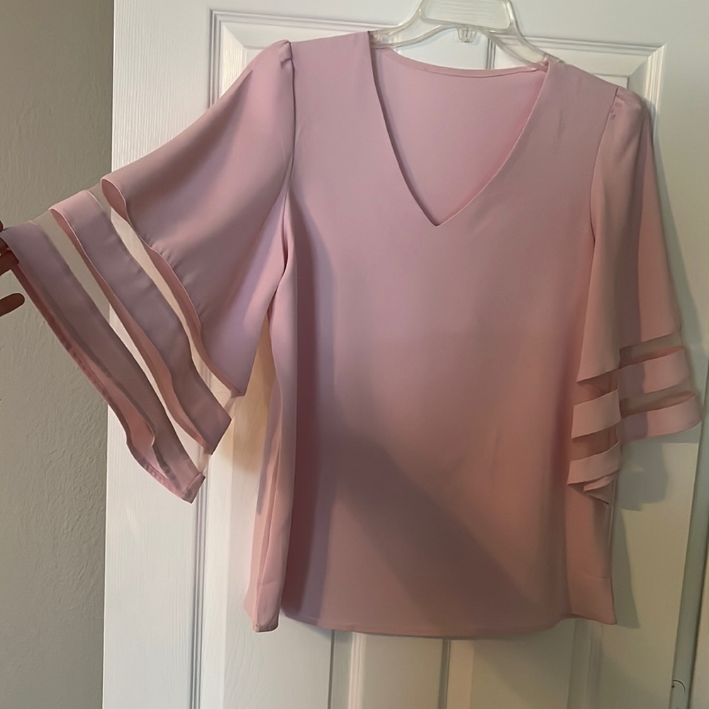 Light pink top. Flowy sleeves with mesh detail.